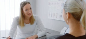 Auf diesem Bild sieht man wie eine Patientin für ihre Behandlung gegen Scheidentrockenheit und weitere Behandlungen wie dauerhafte Haarentfernung beraten wird. Ebenso werden Kosten geklärt, zum beispiel die dauerhafte Haarentfernung kosten.